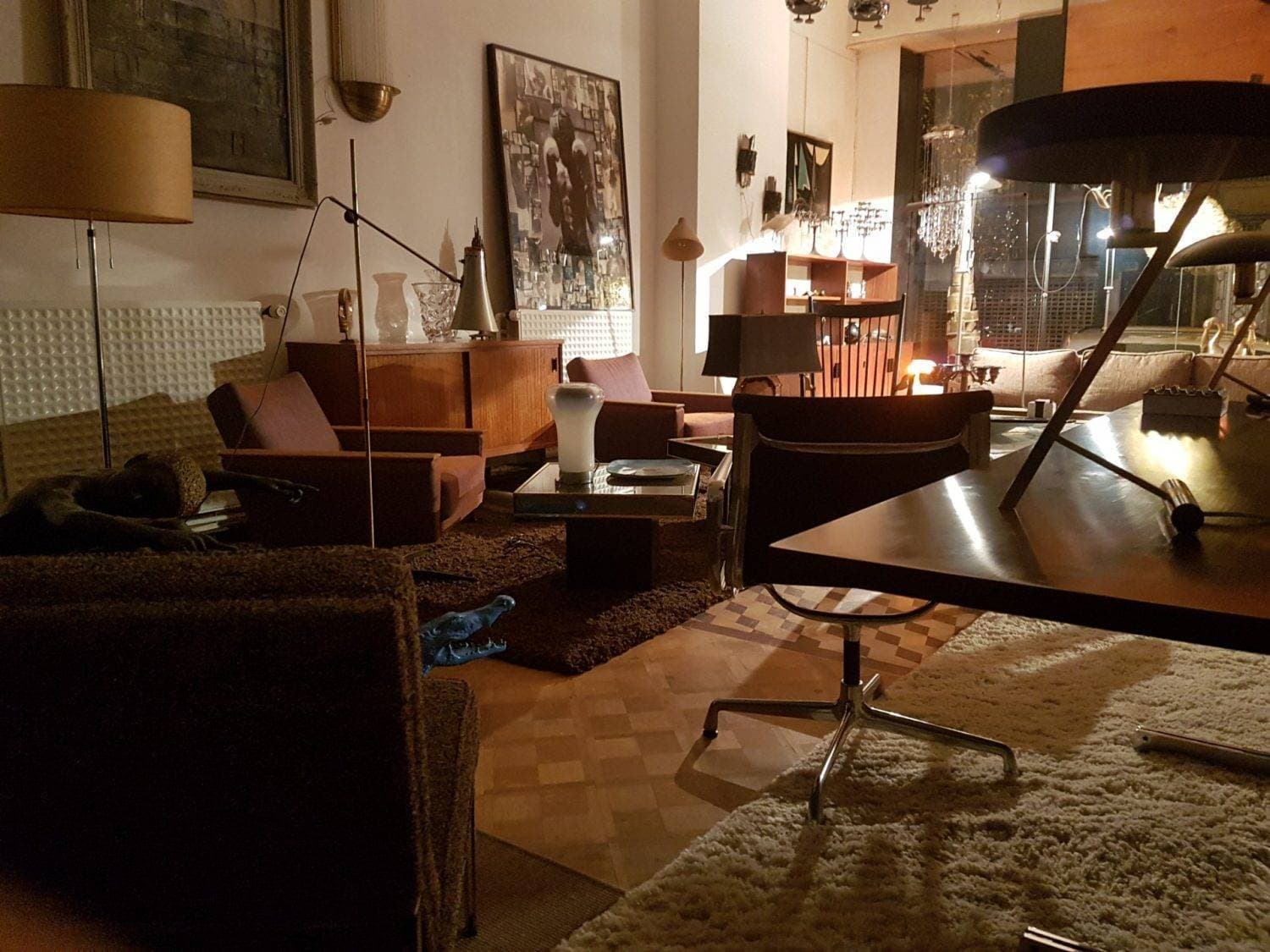 Intérieur de la boutique Benoît de Moffarts à Forest : mobilier vintage, fauteuils et lumière chaude.